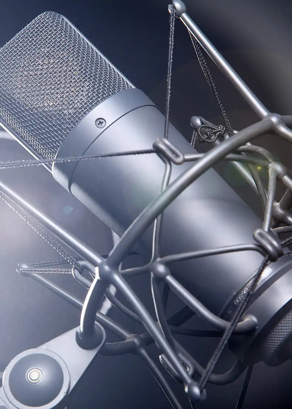 Black condenser microphone with mesh grille and shock mount design, likely a blue yeti model.